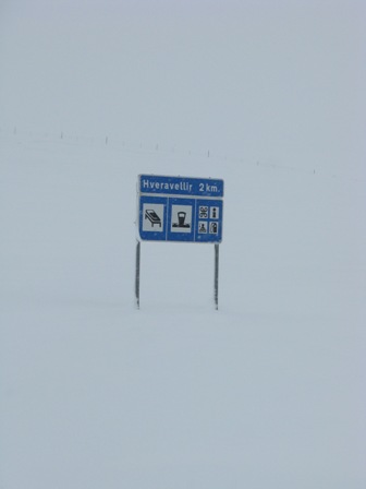 Road sign under snow, which way to the park?